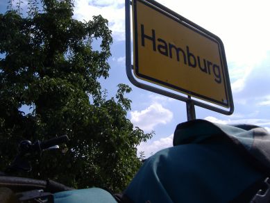 Ortsschild Hamburg mit Fahrradgepäck im Anschnitt