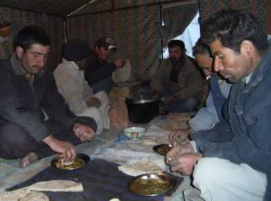 Pakistanische Straßen-Bauarbeiter beim Abendessen in einem Zeltdorf auf 4000 m Höhe, Karakorum Highway (KKH), Pakistan