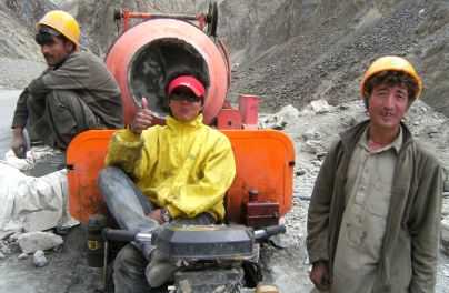 Chinesischer Betonmischer-Fahrer mit pakistanischen Bauarbeitern am Karakorum-Highway (KKH), Pakistan