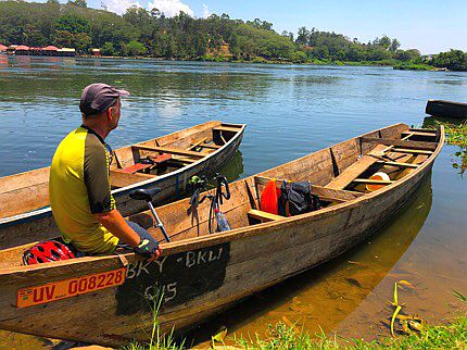 Jinja: Chris on the bike in the fisherman's boat