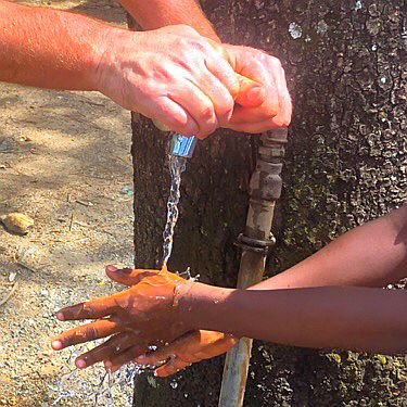 White hand washing black hand