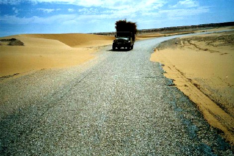 LKW-Gegenverkehr mit Sanddüne in der Sahara
