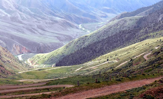Blick von der Passhöhe Terskei-Torpok (3132 m, Тескей-Торпок, Тридцать три Попугаи, Tridzat Tri Popugai, 33 попугая) auf die 33 Serpentinen, die zum Wasserfall und Song-Köl hinabführen