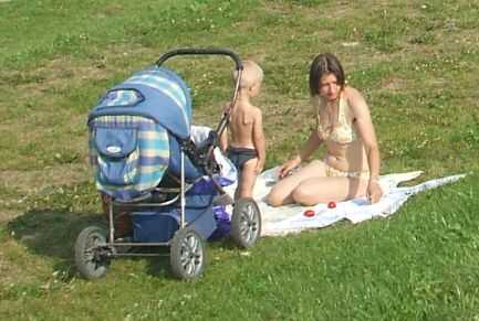 Sonnenbad: Mutter mit Sohn am Ufer der Dwina