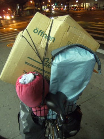 Umzugskartons von Walter Schmitz Möbeltransporte und Umzüge aus Essen, Zelt und Schlafsack im Basil-Korb auf Panther Dominance Trekking bei der Nachtfahrt durch Queens, New York City