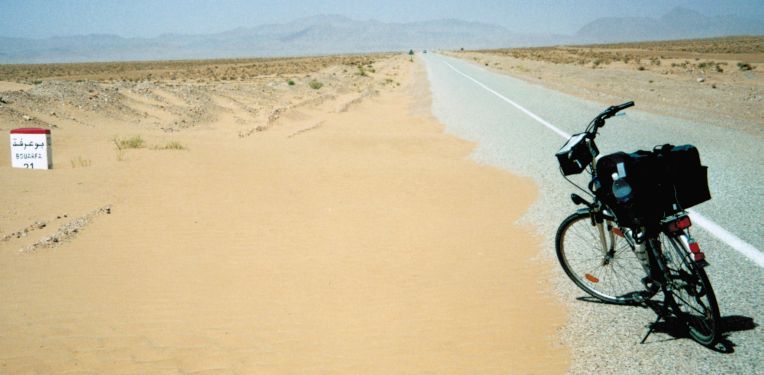 Kilometer-Stein 21 vor Bouarfa: Sand auf der Sahara-Straße, Marokko