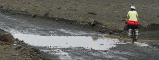 Radlerin auf Piste nach Regen in Island