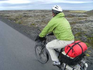 Miri in Vulkand-Landschaft auf dem Radweg zwischen Reykjavík und dem Flughafen von Keflavík mit Meeresblick, Island