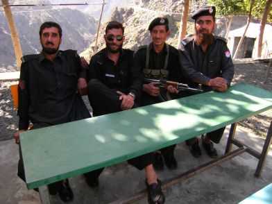 Team-Wechsel: Gut bewaffnete Polizisten der North-Western-Territories begleiten Fahrrad-Fahrer auf dem Karakorum-Highway (KKH) in Indus Kohistan, Pakistan