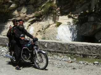Polizei-Moped-Eskorte für Fahrradfahrer mit Knarre und Funkgerät auf dem Karakorum-Highway (KKH), Pakistan