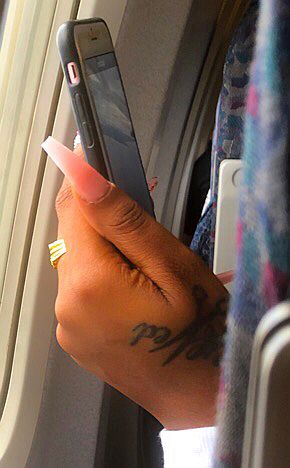 Frauenhand mit Smartphone im Flugzeug