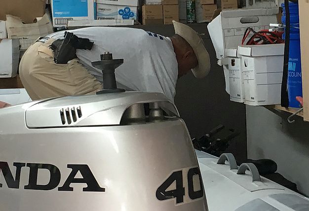 Polizist holt Fahrrad hinter Motorschlauchboot hervor