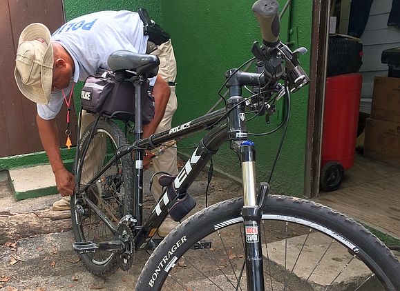 Polizist pumpt Polizei-Fahrrad auf