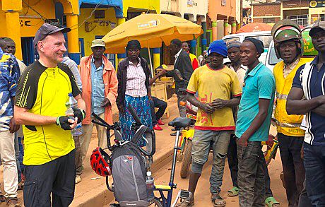 Rukomo/Ruanda: schwarze Männer und weißer Mann mit Faltrad