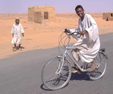 Sudanesischer Junge fährt Fahrrad auf dem Desert-Highway