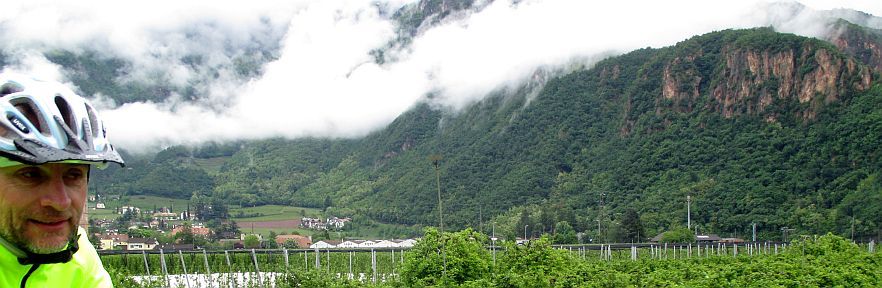 Chris on the Bike auf dem Etsch-/Adige-Radweg vor Regenwolken zwischen Meran und Bozen, Italien