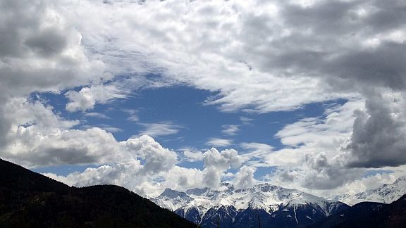 Schneegipfel unter Wolkenpanorama am Reschenpass, Vinschgau, Südtirol, Italien
